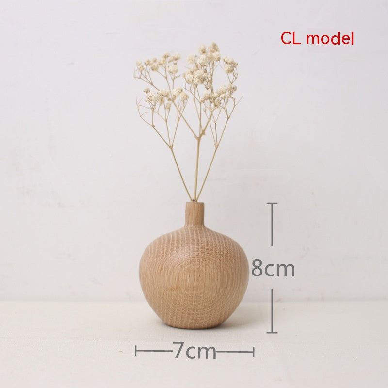 Beige textured vase with dried flowers on a light gray background