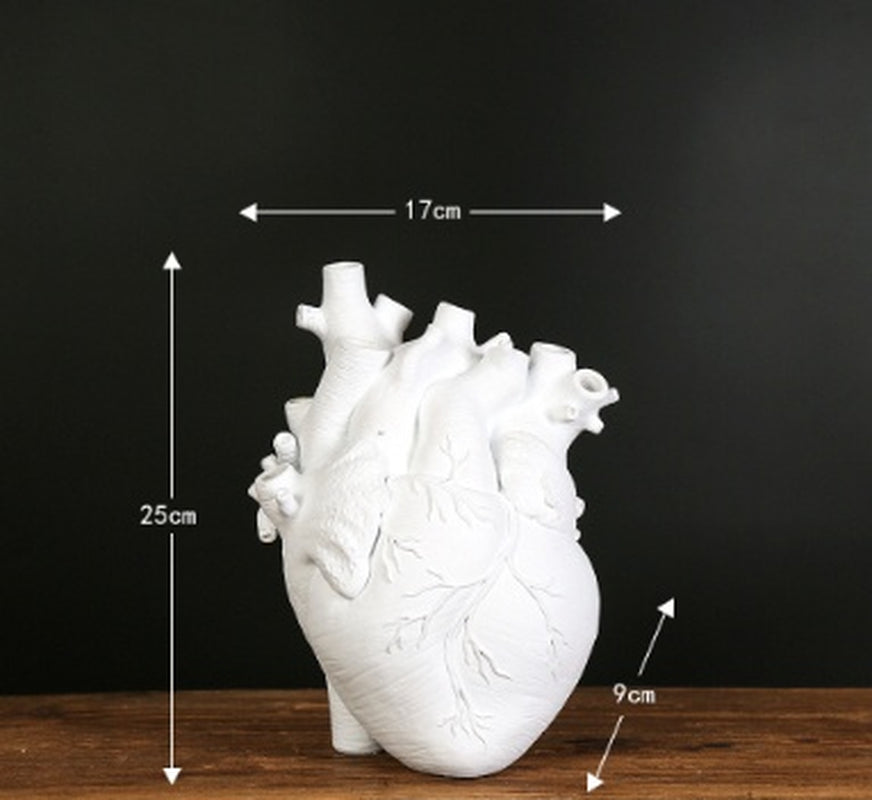 White anatomical heart model with measurements on a dark background