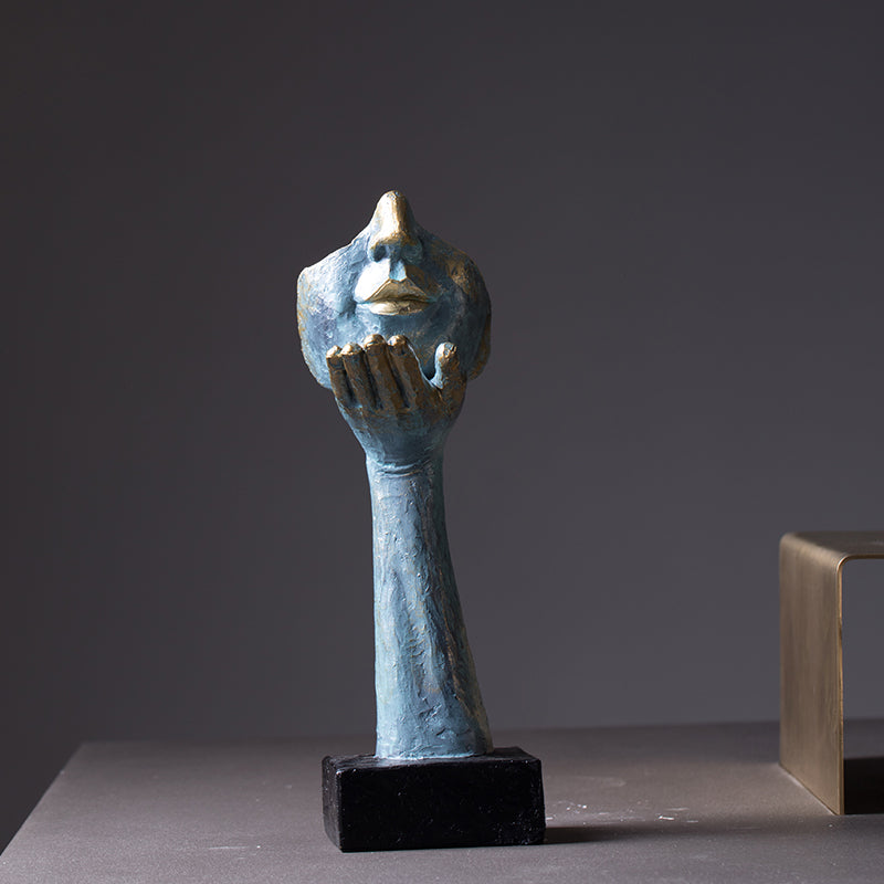 Abstract sculpture of a hand holding a face on a dark background
