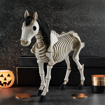 Halloween-themed horse skeleton figure with jack-o'-lantern and candles on a dark background