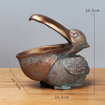 Bronze bird-shaped container with measurements on a wooden surface and gray background