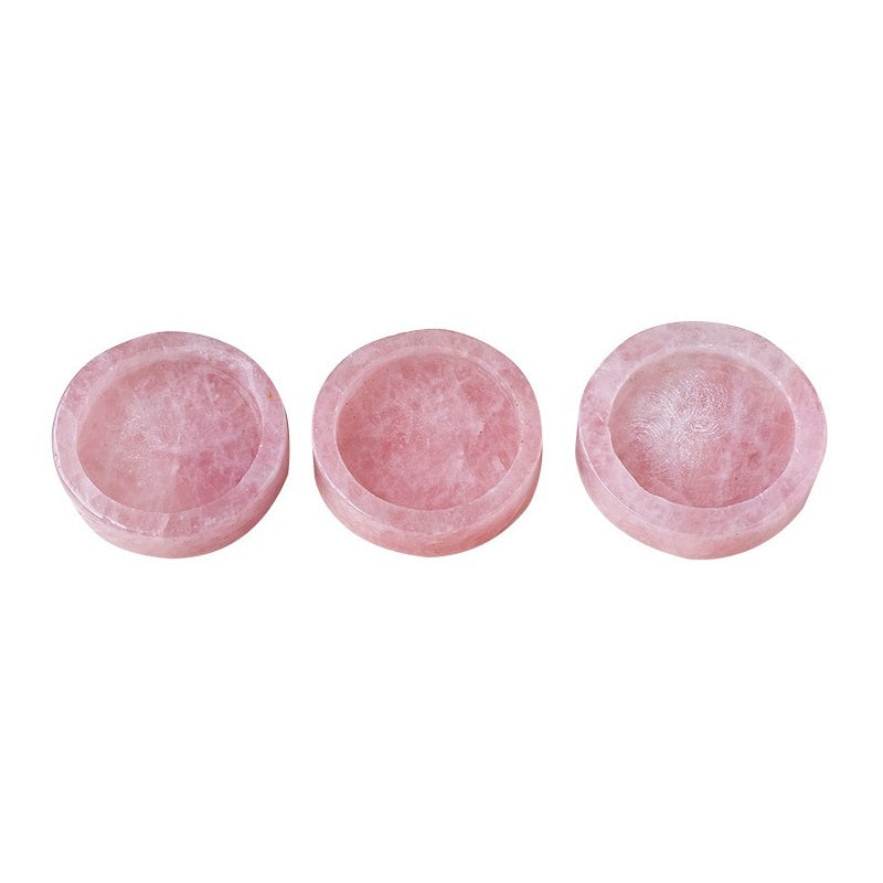Three pink stone bowls on a white background
