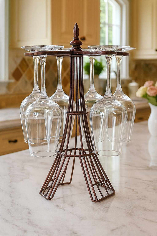 Decorative wine glass stand shaped like the Eiffel Tower on a marble countertop.
