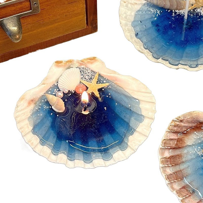 Decorative shell with a candle and starfish on a white background