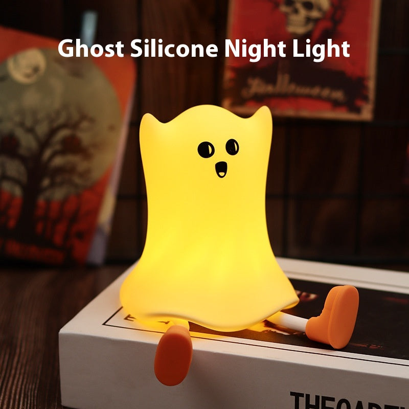 Ghost silicone night light on a surface with Halloween-themed decorations in the background.