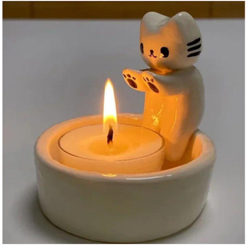 Cat-shaped candle holder with a lit candle inside on a plain background