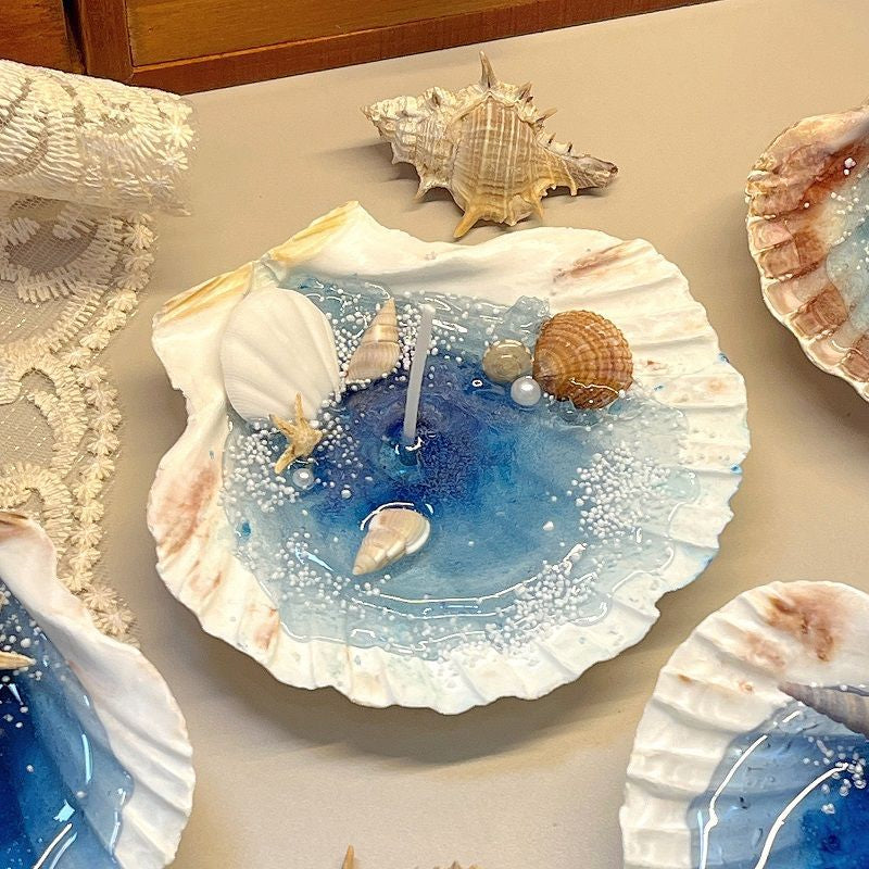 Decorative shell with blue water and seashells on a lace tablecloth