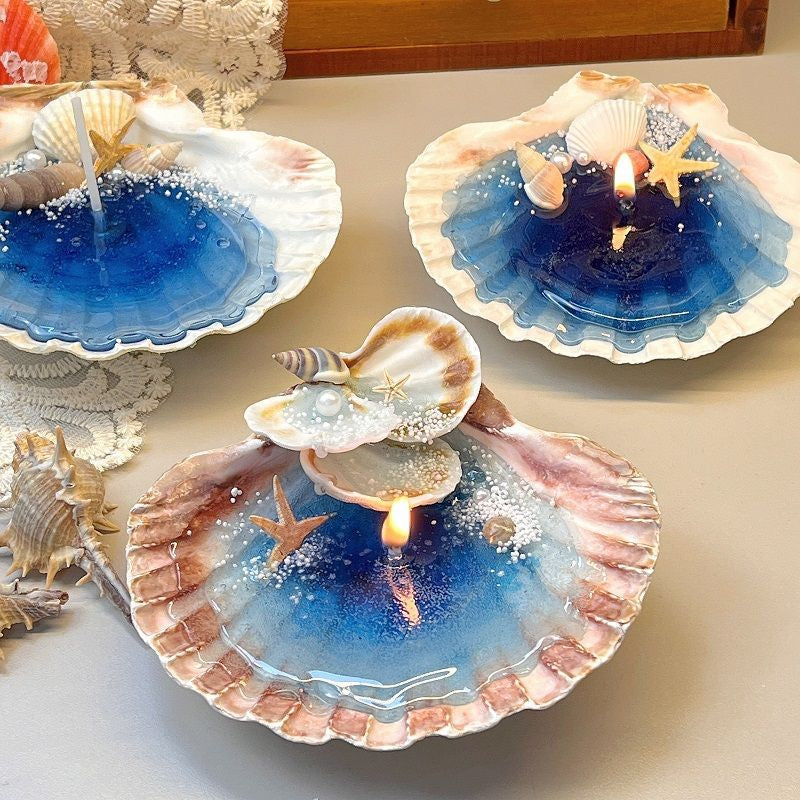 Decorative candles in shell molds with blue wax and starfish on a light background