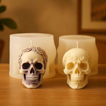 Two skull-shaped candles on a wooden surface with a warm background