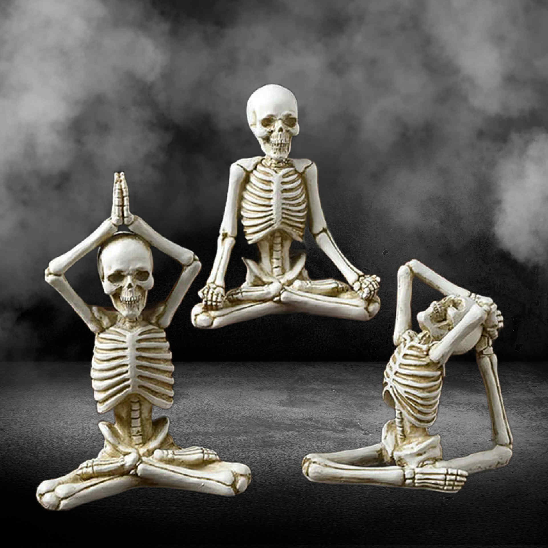 Three skeleton figurines in yoga poses against a dark background