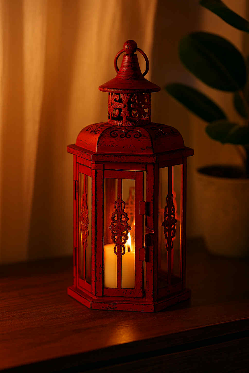 Red lantern with a lit candle inside on a wooden surface.