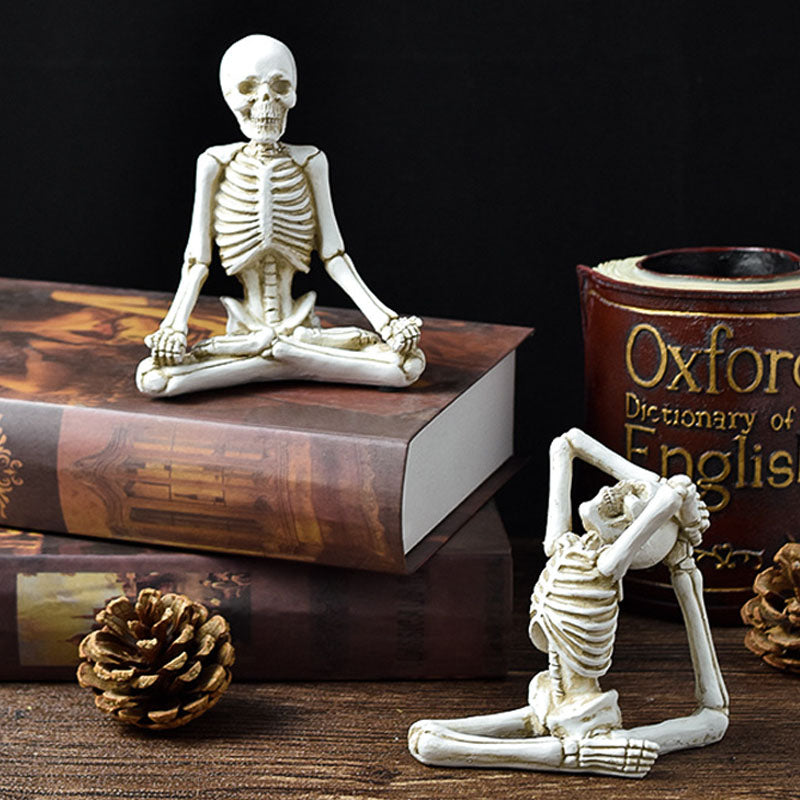 Two skeleton figurines on books with a 'Dictionary of English' book in the background.